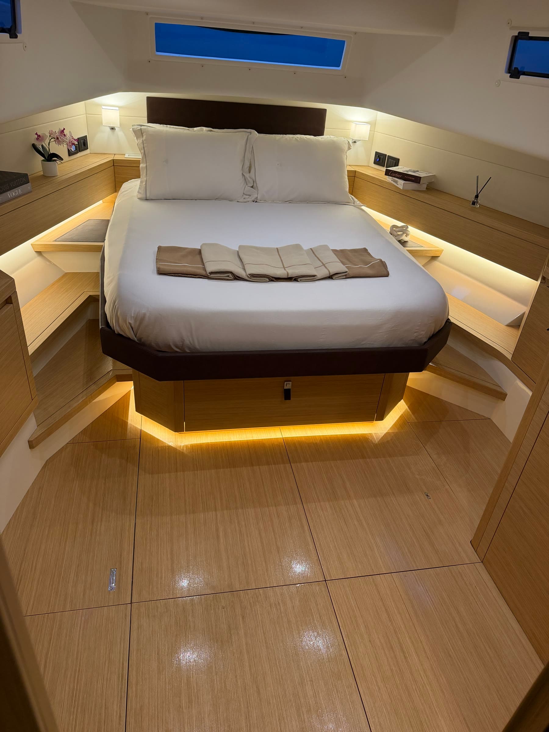 Illuminated forward yacht cabin prepared for guests
